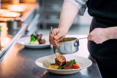 A close-up of a chef preparing a dish